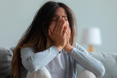 Плачет закрыв лицо руками