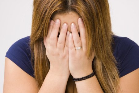 Женщина закрывает лицо