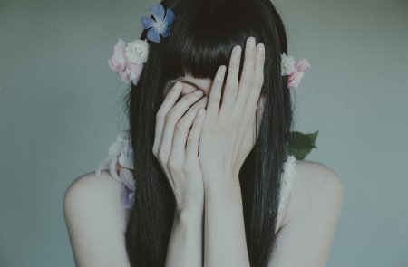 Девушка прикрывает лицо рукой