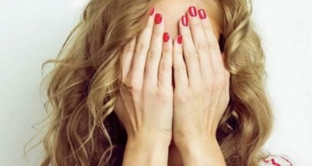 Женщина закрывает лицо руками