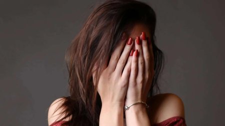 Девушка прикрывает лицо рукой