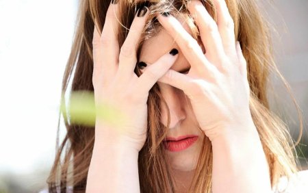 Женщина закрывает лицо руками