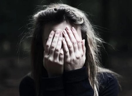 Девушка закрывает лицо руками