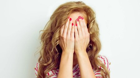 Женщина закрывает лицо руками