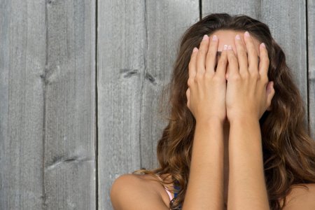 Девушка закрывает лицо