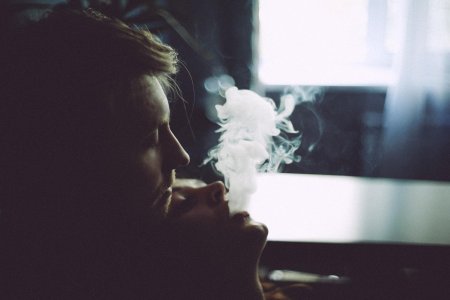 Парень выдыхает дым