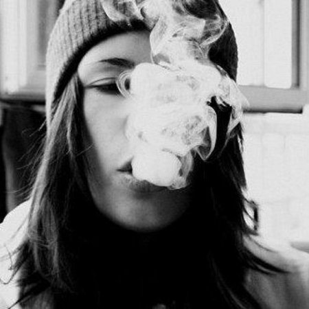 Девушка выдыхает дым