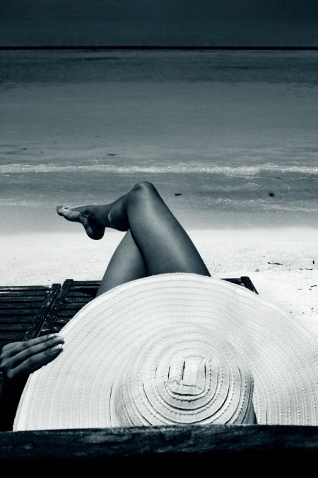 Девушка в шляпе на море спиной