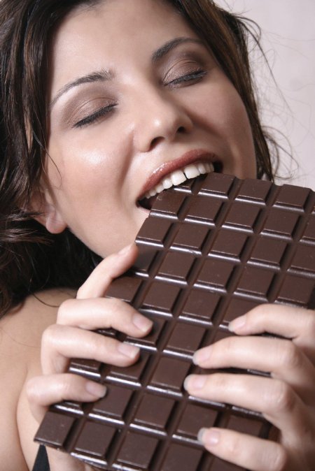 Девушка ест шоколад
