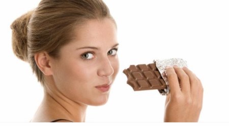 Девушка ест шоколад