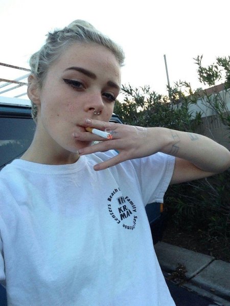 Девушка с белыми волосами курит