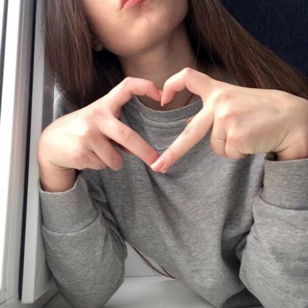 Девушка показывает сердечко