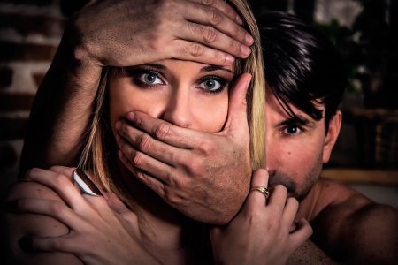 Прикрывает рот рукой