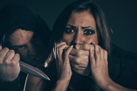 Закрывает рот рукой