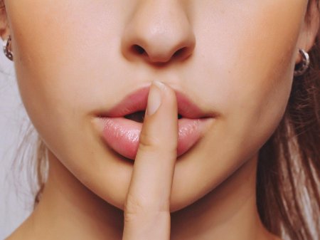 Девушка с пальцем у губ