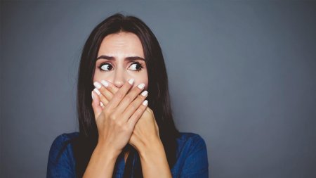 Девушка прикрывает рот рукой