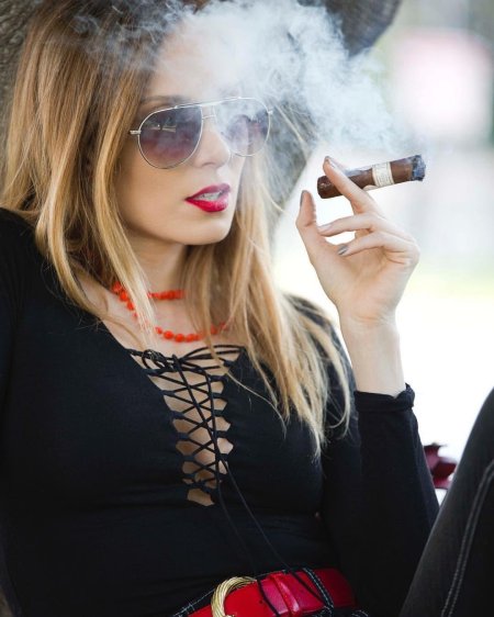 Девушка в очках с сигарой