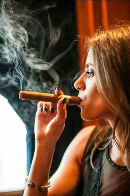 Девушка курит сигару