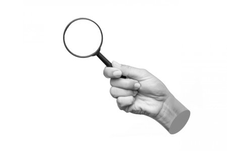 Рука держит лупу