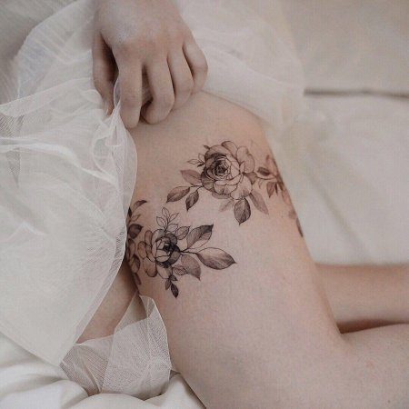 Женская татуировка на бедре