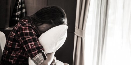 Девушка плачет в подушку