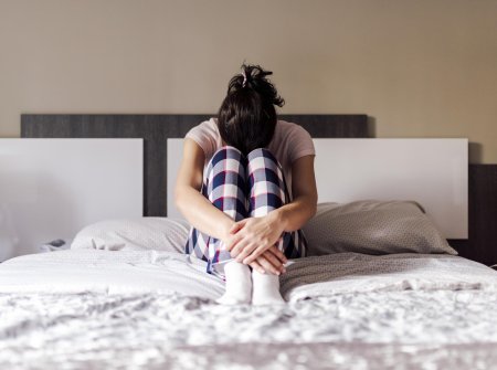 Девушка плачет на кровати