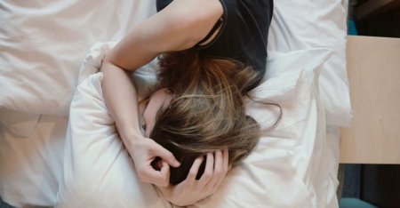 Девушка плачет на кровати