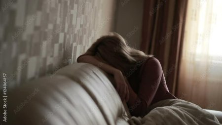 Девушка плачет на кровати