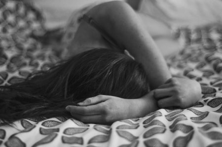 Девушка плачет на кровати