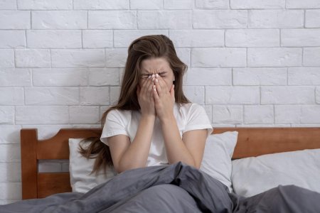 Девушка плачет на кровати