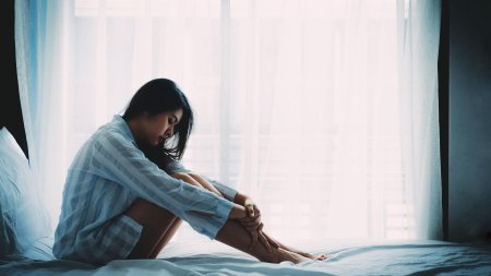 Грустная девушка на кровати