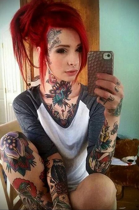 Рыжая девушка с пирсингом и тату
