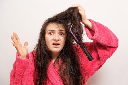 Young woman combing her hair