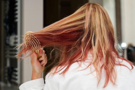 Девушка расчесывает волосы