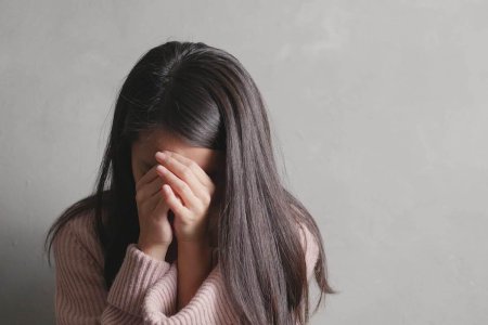 Девушка прикрывает лицо