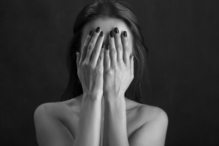 Женщина закрывает лицо