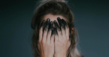 Закрывает лицо руками