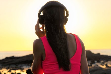 Девушка в наушниках со спины