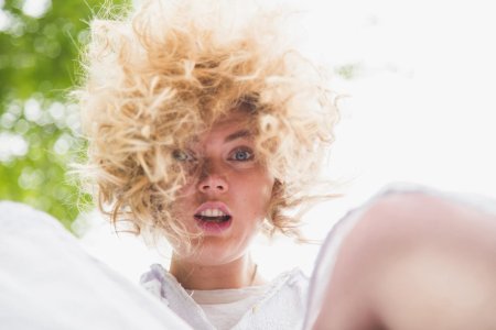 Девушка блондинка с закрытыми глазами волосами на лице