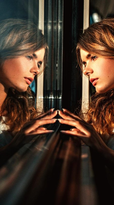 Девушка смотрит в зеркало