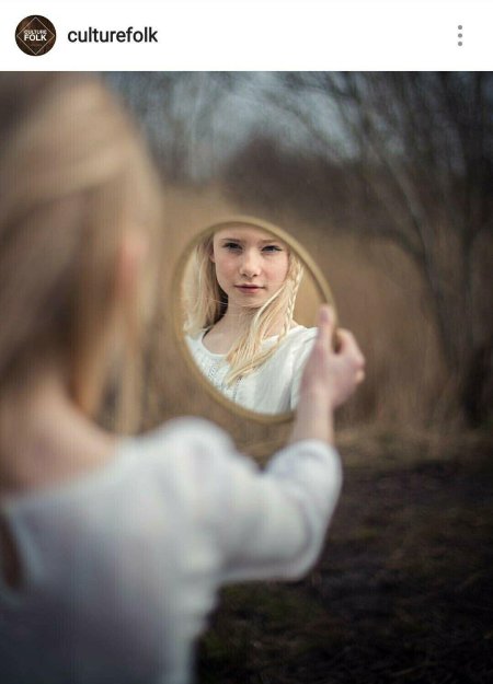 Девушка смотрится в зеркало