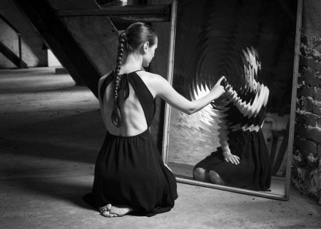 Девушка смотрится в зеркало