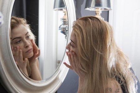 Девушка смотрится в зеркало