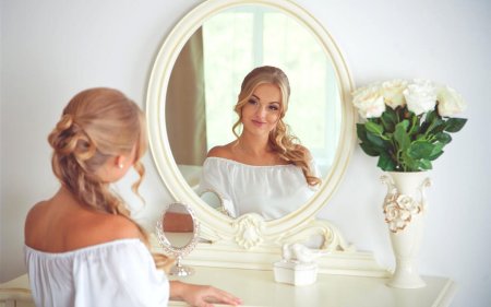 Женщина смотрится в зеркало