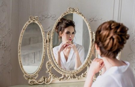Девушка смотрится в зеркало