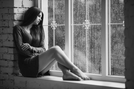 Девушка грустит у окна