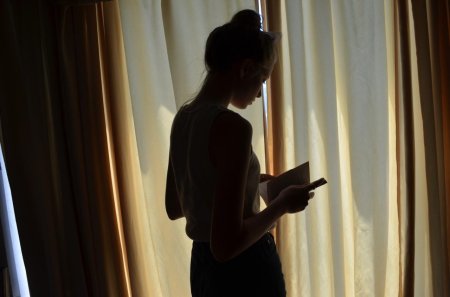 Женщина спиной у окна