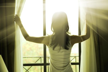 Девушка открывает шторы