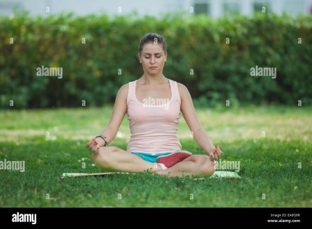 Девушка сидит в поле позе лотоса