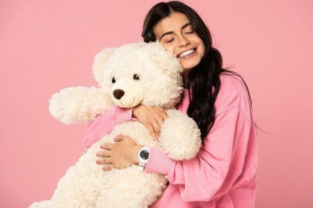 Девушка обнимает мягкую игрушку